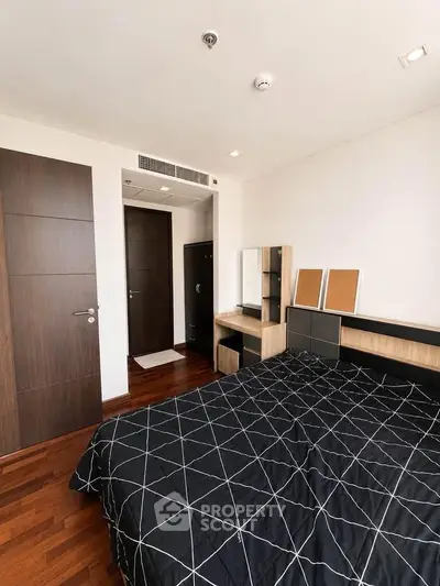 Modern bedroom with stylish decor and wooden flooring in a contemporary apartment.