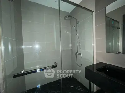 Modern bathroom with sleek glass shower and elegant black sink