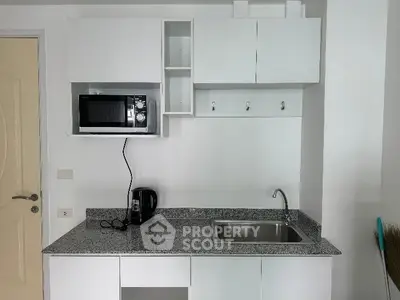 Modern compact kitchen with microwave and sleek countertop
