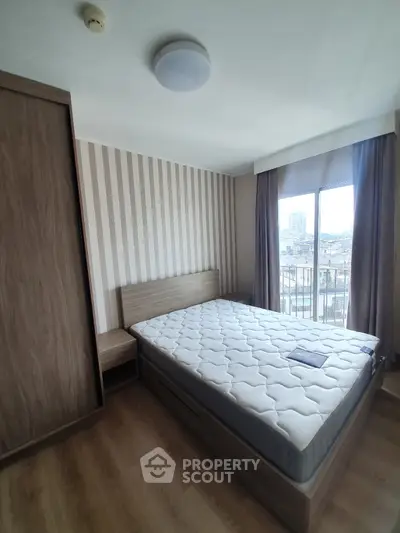 Modern bedroom with city view, featuring a comfortable bed and stylish decor.