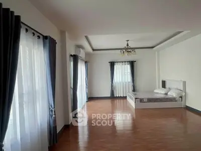 Spacious bedroom with elegant curtains and wooden flooring