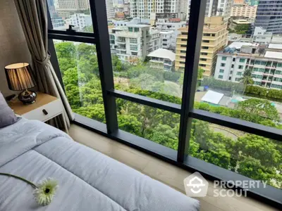 Luxurious bedroom with stunning city view from floor-to-ceiling windows in modern high-rise apartment.