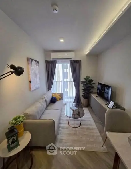 Modern living room with cozy sofa, stylish decor, and natural light from large window.