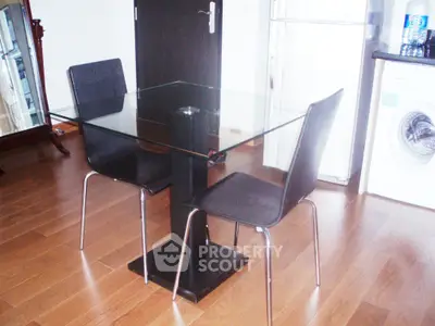 Modern dining area with glass table and sleek chairs in a stylish apartment.