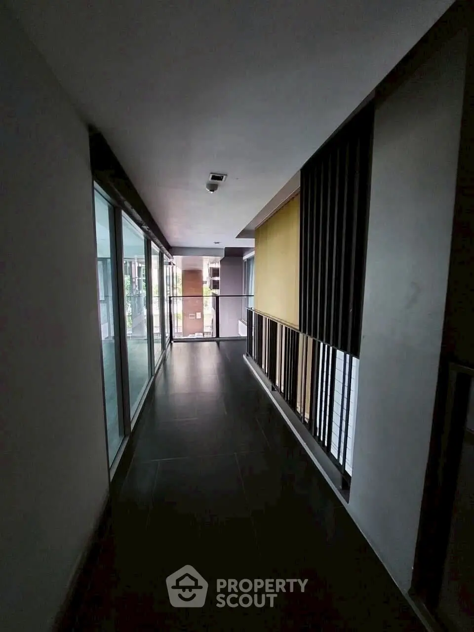 Modern corridor with sleek design and glass walls in a contemporary building.