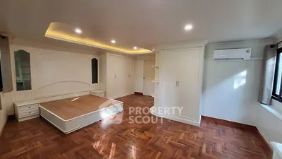 Spacious bedroom with elegant wooden flooring and built-in storage