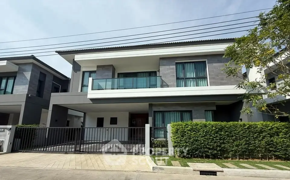 Modern two-story house with sleek design and spacious balcony in a serene neighborhood.