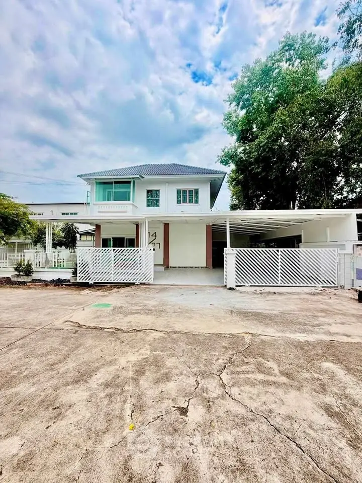 Charming two-story house with spacious driveway and lush greenery, perfect for family living.