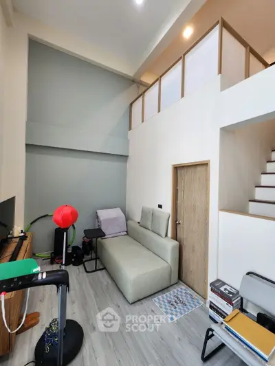 Modern living room with high ceiling and mezzanine, featuring stylish furniture and sleek design.