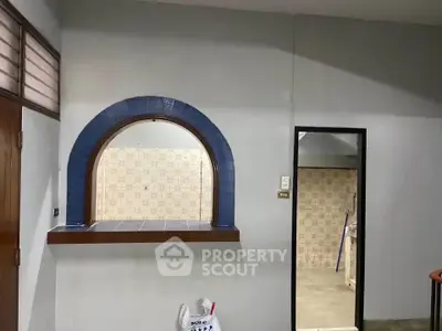Charming interior with unique arched window and tiled accents, perfect for creative renovation.