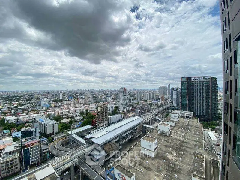 Stunning cityscape view from high-rise building overlooking urban skyline and transit station.