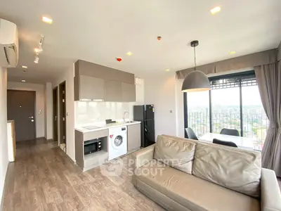 Modern open-plan living room with kitchen and city view, featuring sleek furniture and appliances.