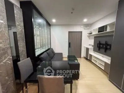 Modern living room with sleek furniture and glass dining table in a stylish apartment.