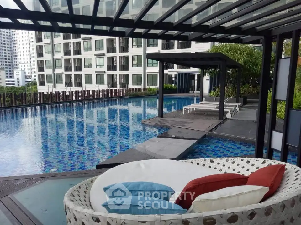Luxurious poolside area with modern seating and stunning city views in a high-rise residential complex.