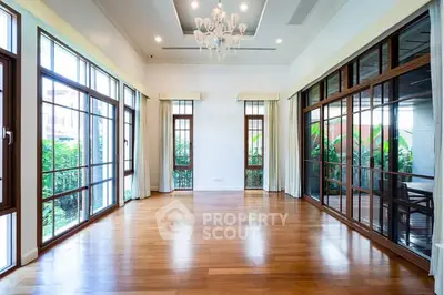 Spacious living room with hardwood floors and large windows for natural light.