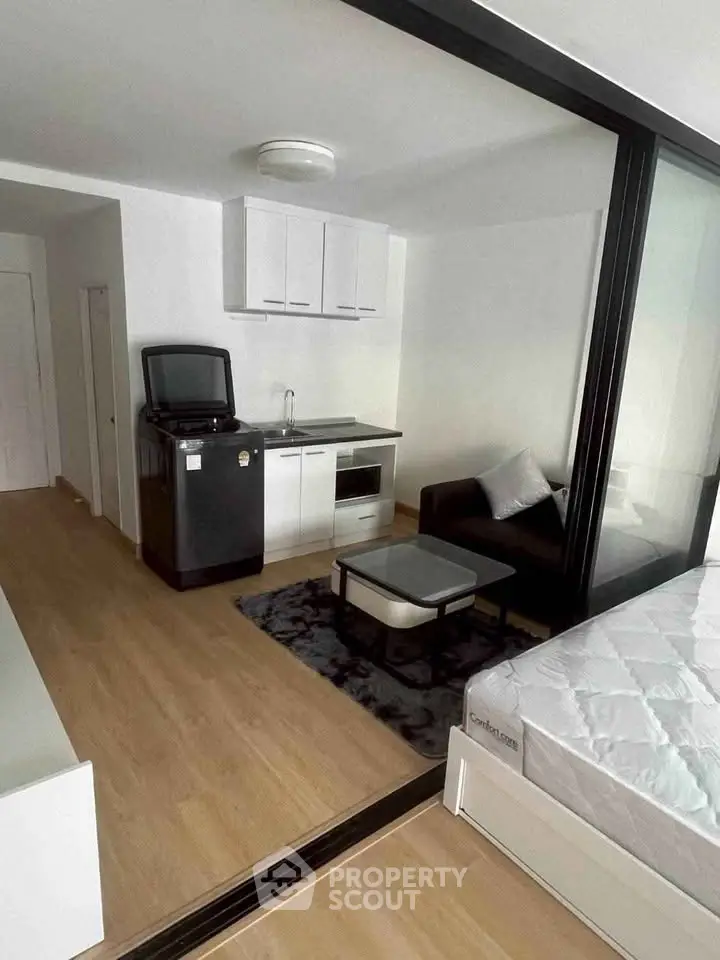 Modern studio apartment with sleek kitchen and cozy living area