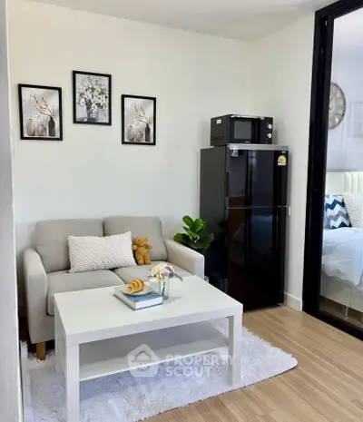 Charming living room with cozy sofa, modern decor, and compact kitchen appliances in a stylish apartment.