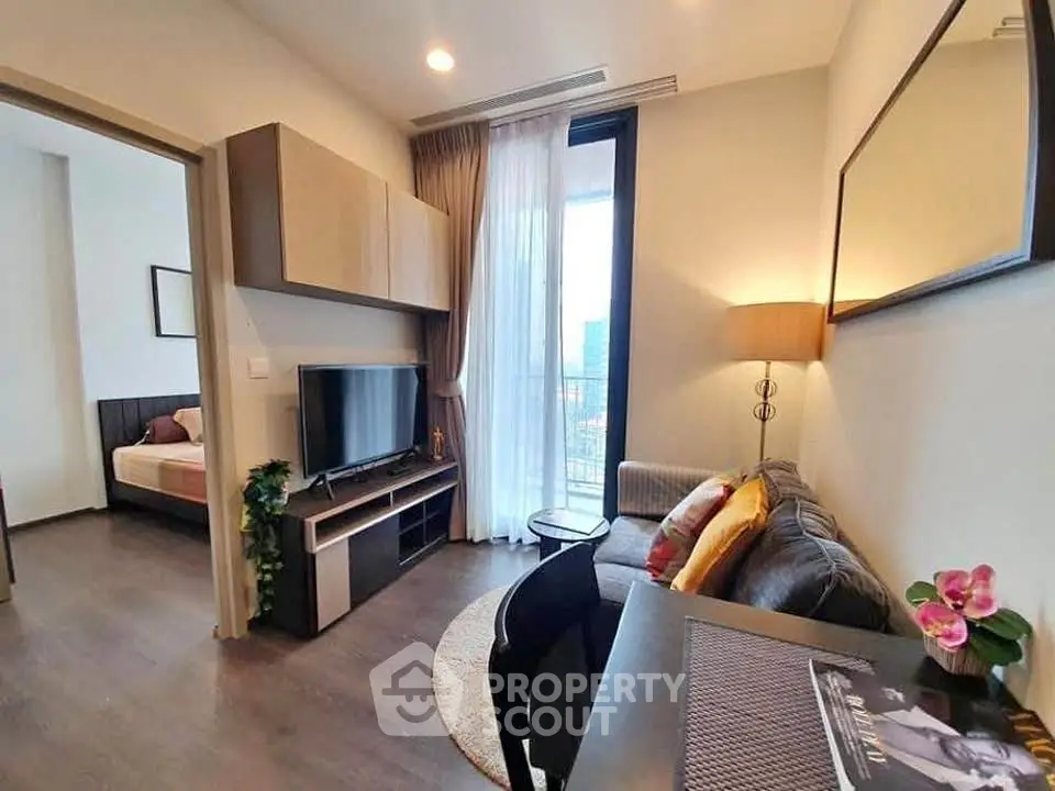 Modern living room with cozy sofa, TV, and balcony view in stylish apartment.