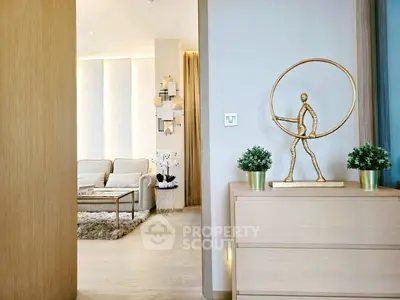 Modern living room with elegant decor and stylish furnishings, featuring a unique sculpture and cozy seating area.
