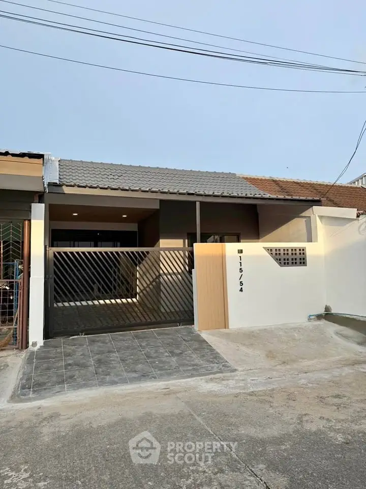 Charming single-story home with modern facade and secure gated entrance.