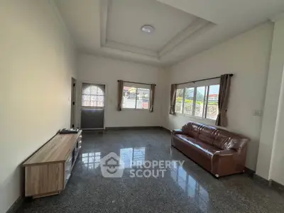 Spacious living room with large windows and modern furniture in a bright home.