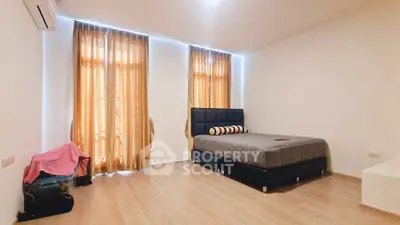 Spacious bedroom with large windows and modern furnishings