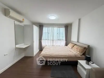 Spacious bedroom with modern furnishings and natural light in a stylish apartment.