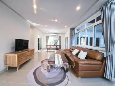 Spacious living room with modern decor and large windows in a luxury apartment.