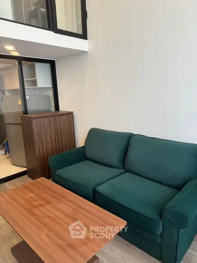 Modern living room with green sofa and wooden coffee table in stylish apartment