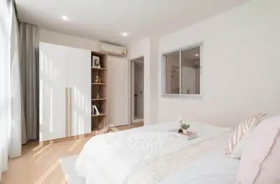 Bright and cozy bedroom with modern decor and ample natural light.