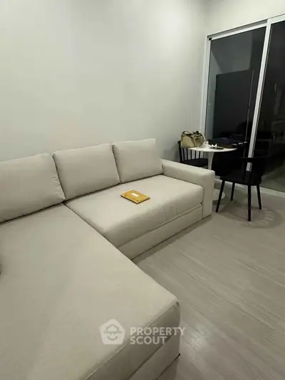 Modern living room with beige sectional sofa and sleek dining area