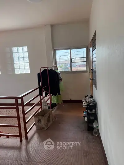 Spacious hallway with natural light and storage space, ideal for organizing and maximizing home functionality.