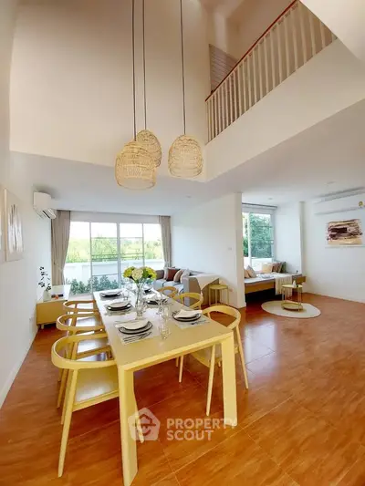 Spacious modern living room with high ceiling and elegant dining area