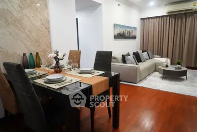 Elegant living room with stylish dining area, featuring modern furniture and warm wooden flooring.