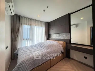 Modern bedroom with stylish decor and large window for natural light.