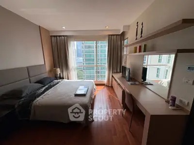 Modern bedroom with city view, featuring a cozy bed and sleek workspace.