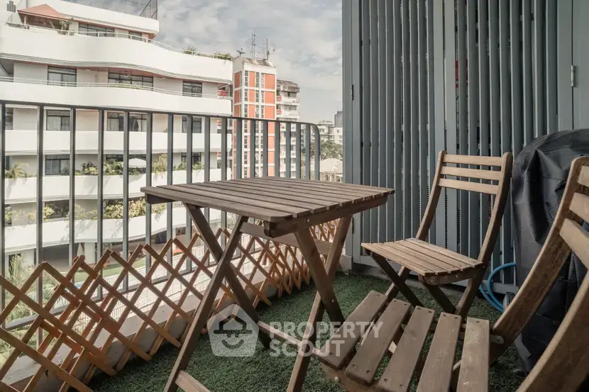 Charming balcony with wooden furniture and city view, perfect for relaxing outdoors.