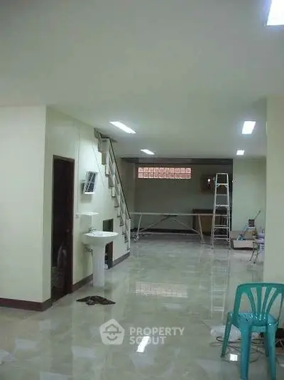 Spacious interior with ladder access and tiled flooring, ideal for versatile use.