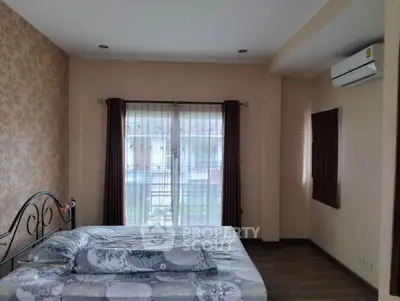 Cozy bedroom with floral wallpaper and large window for natural light