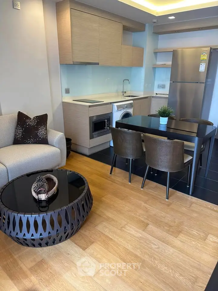 Modern open-layout kitchen and living area with sleek appliances and stylish furniture.