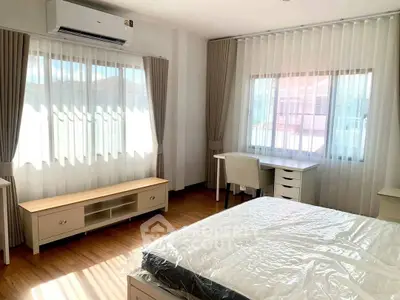 Bright and airy bedroom with large windows and modern furnishings