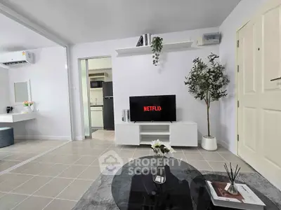 Modern living room with sleek decor and open layout, featuring a TV and stylish furniture.