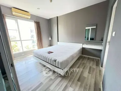 Modern bedroom with large window and minimalist decor in a stylish apartment.