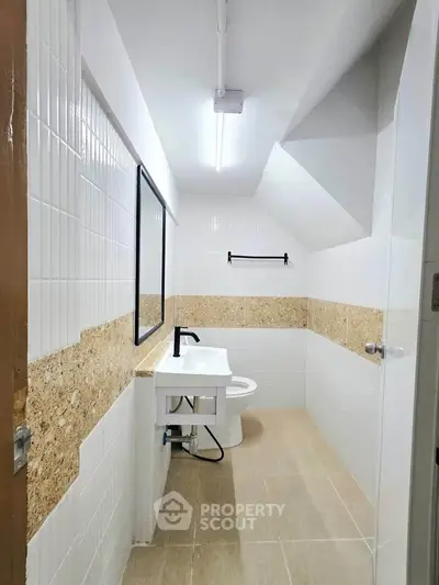 Modern bathroom with sleek design and neutral tones, featuring a stylish sink and contemporary fixtures.