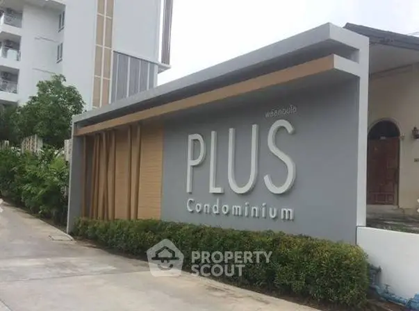 Modern entrance of Plus Condominium with sleek architectural design and lush greenery.