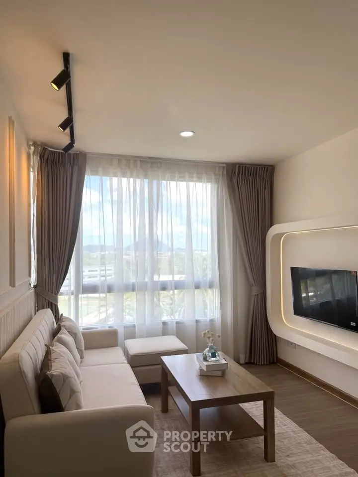 Bright and cozy living room with modern decor and large window view.