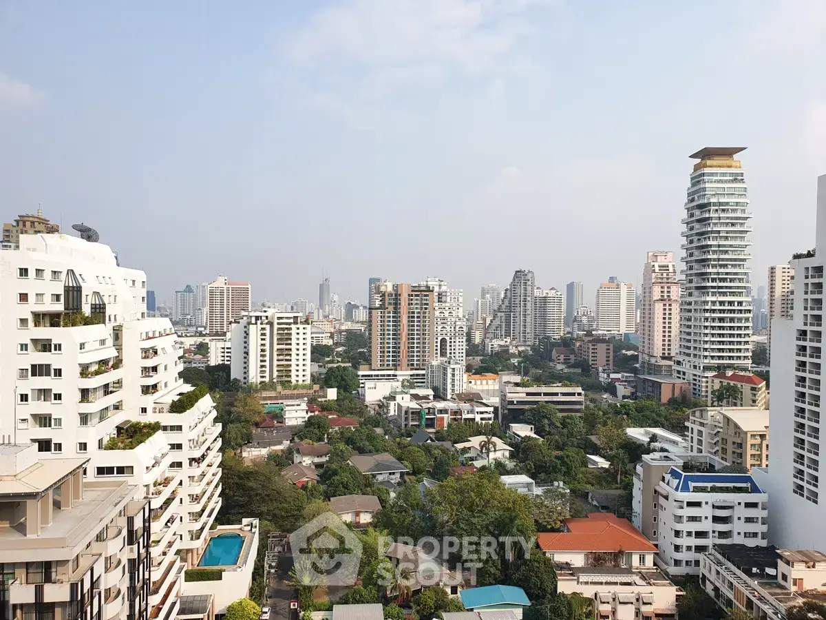 Stunning cityscape view from a high-rise building showcasing urban skyline and lush greenery.
