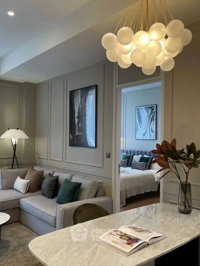 Elegant living room with modern chandelier and cozy bedroom view