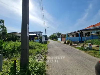 Charming suburban street view with lush greenery and cozy homes under a clear blue sky.