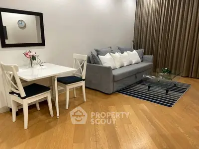 Charming living room with cozy sofa, elegant dining set, and stylish decor on wooden flooring.